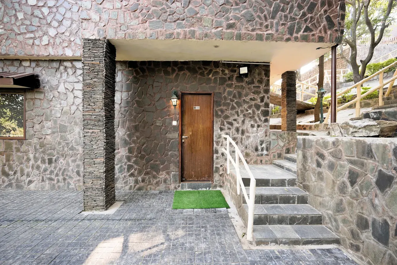 Stone villa entrance with wooden door and steps